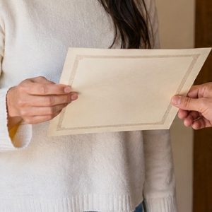 Pessoa recebendo uma certidão em casa, em um ambiente acolhedor e bem iluminado, transmitindo praticidade, segurança e comodidade no recebimento do documento